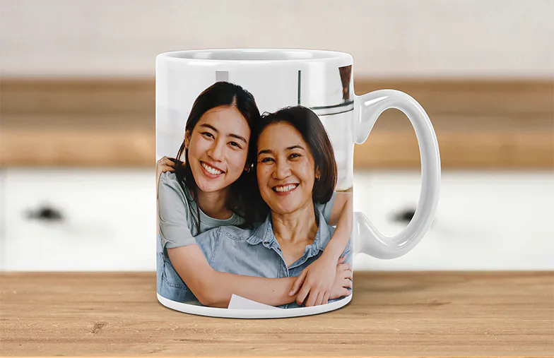 Tazze Foto Personalizzate da Printerpix|Mamma e bambino che tengono una tazza personalizzata con design a cartone animato di Printerpix con testo per papà|Tazza foto personalizzata con immagine di bambino che gattona indossando una tutina da animale|Mamma e figlia che tengono tazze foto personalizzate con foto di famiglia|Coppia che si bacia con tazze personalizzate con testo|Tazza foto personalizzata con la tua foto di un cane