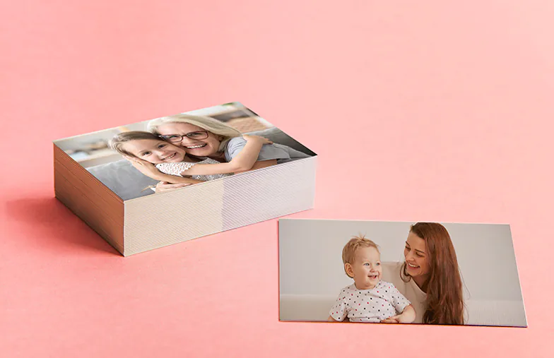 Stampe fotografiche piccole, medie e grandi sul tavolo dal telefono cellulare